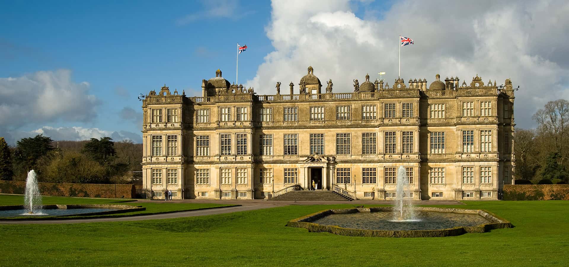 Longleat Manor House & Wild Safari Tour. Historic English manor house with manicured gardens and fountains, showcasing classic UK architecture and royal heritage near popular tourist attractions.